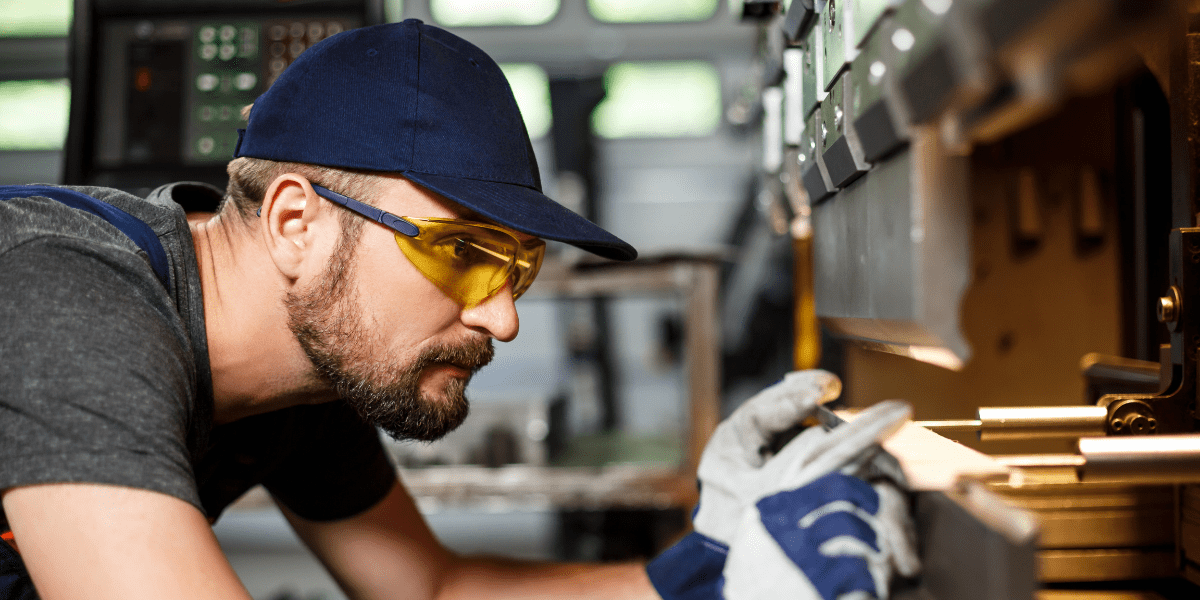 man lining up part for pressing machine