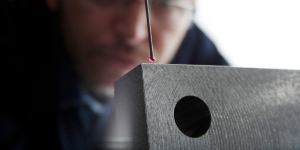 close up of a Coordinate Measuring Machine with a man in the background