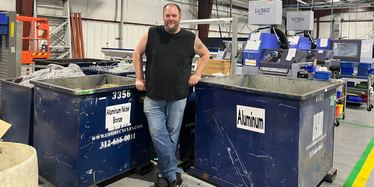 Man standing in front of recycling bins